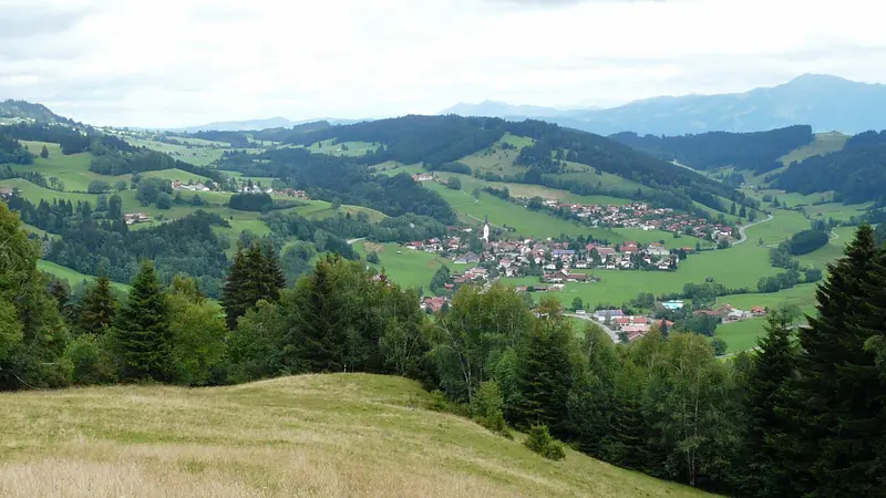 Blick vom Ochsenberg auf Missen im Tal, umgeben von Wiesen, Wäldern und Allgäuer Bergen