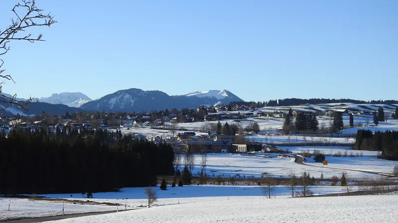 Oy-Mittelberg im Winter, Blick von Norden über verschneite Wiesen auf den Ortsteil Oy und die Allgäuer Berge