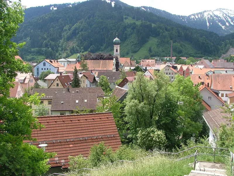 Blick über die Dächer der Altstadt von Immenstadt im Allgäu mit dem Turm der Stadtpfarrkirche St. Nikolaus vor bewaldeten Bergen