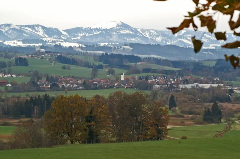 Herbstlicher Blick von Nordwesten auf Betzigau mit den Allgäuer Alpen im Hintergrund